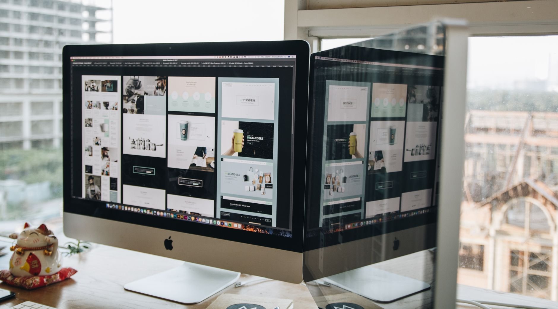Dual monitors showing web design in a modern office setting